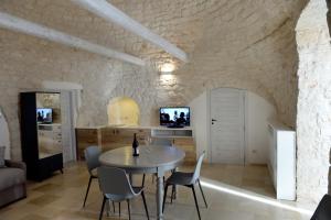 een keuken en eetkamer met een tafel en stoelen bij Trullo Vino & Amore in Alberobello
