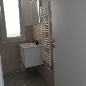 baño con lavabo blanco y ventana en Casa Aurora en Terrasini