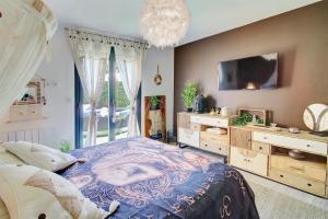 a bedroom with a bed and a tv and a window at O jardin des Sens -Séjour Bien-être & détente &Jacuzzi in Béziers