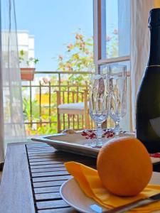 ラーカレにあるGlem B&Bのワイングラス2杯とオレンジが付いたテーブル