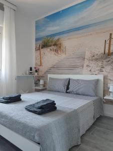 1 dormitorio con 1 cama y una pintura de playa en b&b Casa Balai 72 a 150 mt dal mare en Porto Torres