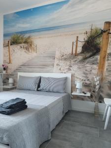 1 dormitorio con 1 cama y un mural de playa en b&b Casa Balai 72 a 150 mt dal mare en Porto Torres