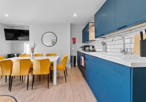 a kitchen with a dining table and yellow chairs at Valley Garden View 4 By My Getaways in Brighton & Hove