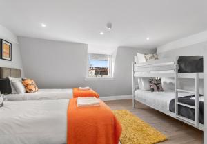1 dormitorio con 2 literas y manta naranja en Valley Garden View 4 By My Getaways en Brighton & Hove