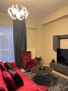 a living room with a red couch and a tv at Luxury hotel apartment in Istanbul