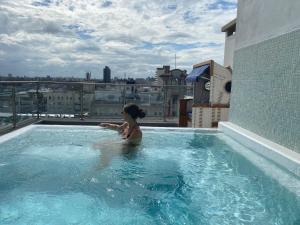 una mujer en una piscina en la parte superior de un edificio en Puertovideo, en Montevideo