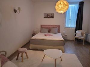 um pequeno quarto com uma cama e um lustre em Chambre d'hôte chez l'habitant em Revel