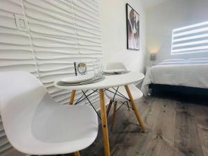 een kamer met een tafel, 2 stoelen en een bed bij Alma Guest Suite in Miami