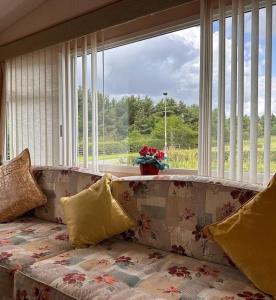 un sofá en una sala de estar con una gran ventana en 4-Bedroom Cosalt Parkhome in Uddingston, Glasgow en Uddingston