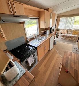 una caravana con cocina con fogones y fregadero. en 4-Bedroom Cosalt Parkhome in Uddingston, Glasgow en Uddingston