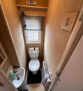 a small bathroom with a toilet and a sink at 4-Bedroom Cosalt Parkhome in Uddingston, Glasgow in Uddingston