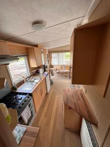 a small kitchen with a stove and a sink at 4-Bedroom Cosalt Parkhome in Uddingston, Glasgow in Uddingston