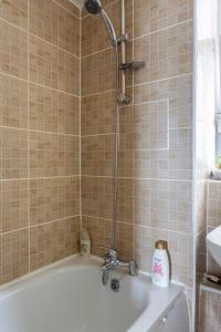 a shower in a bathroom with a bath tub at Home From Home in London