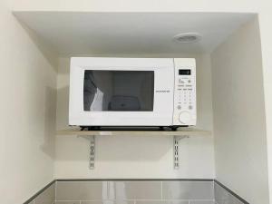 a microwave oven on a shelf in a kitchen at Alma Guest Suite in Miami