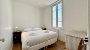 a white bedroom with a bed and a window at Nolette en baie maison de campagne in Noyelles-sur-Mer