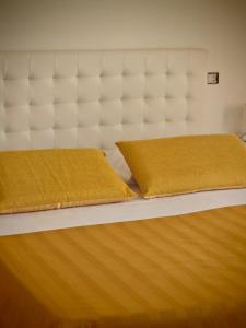 ラーカレにあるGlem B&Bのベッドルーム(白いベッド、黄色い枕付)