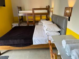 een slaapkamer met 2 stapelbedden en een tafel bij Pequena Mykonos in Penha