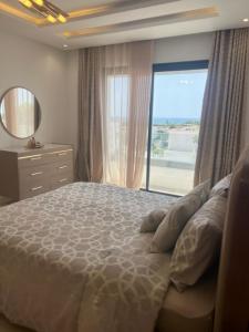 a bedroom with a large bed with a large window at Residence prestige in Nabeul