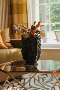 un jarrón de flores sentado en una mesa de cristal en Villa Nußbaumer - Business-und Ferienwohnung in bester Lage en Arnstadt