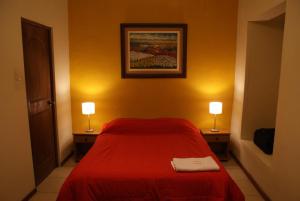 ein Schlafzimmer mit einem roten Bett und zwei Lampen auf beiden Seiten in der Unterkunft Flying Dog Hostel Arequipa in Arequipa