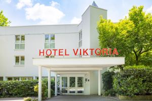 um hotel Viktoria edifício com um sinal nele em Concorde Hotel Viktoria em Kronberg im Taunus