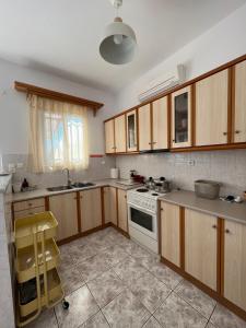a kitchen with wooden cabinets and a white stove top oven at Harry's House in Elafonisos