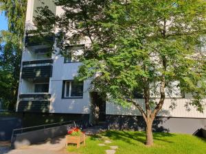 a tree in front of a building with flowers in a box at Tina's Apartment in Pori