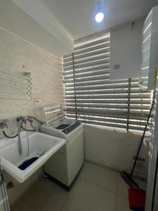 a small kitchen with a sink and a window at Amplio Departamento - Edificio Tranquilo in Antofagasta