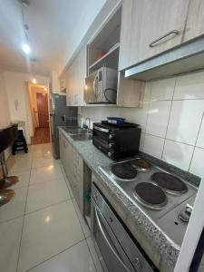 uma cozinha com um fogão e uma bancada em Amplio Departamento - Edificio Tranquilo em Antofagasta