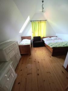 a room with two beds and a chair in it at Agroturystyka przy szlaku na Sokolicę in Krościenko