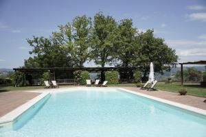 a swimming pool with chairs and a pavilion at Il Castellaro Country House in Perugia