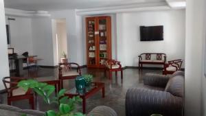 a living room with couches and a flat screen tv at Hotel Alvorada in Goiânia
