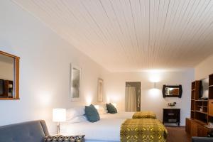 ein Schlafzimmer mit einem großen Bett und einer weißen Decke in der Unterkunft The Kent Motel in Niagara on the Lake