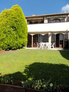 ein Haus mit einem grünen Garten mit einem Baum in der Unterkunft Maison de 2 chambres avec vue sur la mer piscine partagee et jardin clos a Mouans Sartoux in Mouans-Sartoux