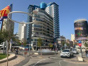 una calle de la ciudad con coches delante de edificios altos en Apartamentos Aurea, en Benidorm