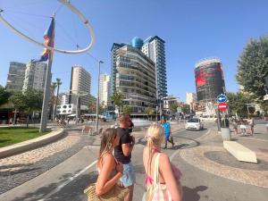 un grupo de personas de pie en una calle de la ciudad en Apartamentos Aurea en Benidorm