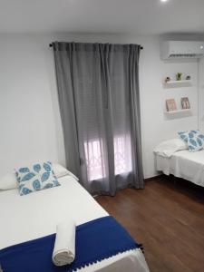 um quarto com 2 camas e uma janela em Apartamento Madreselva 36 em Granada