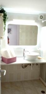 a bathroom with a sink and a mirror at Andros Lighthouse Apartments in Mesariá