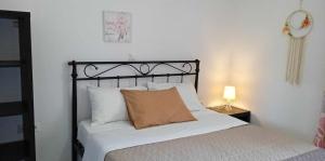 a bed with a brown pillow on it in a bedroom at Andros Lighthouse Apartments in Mesariá
