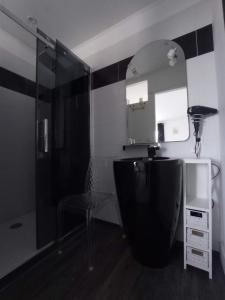 y baño con ducha, lavabo y espejo. en La Douce Parenthèse - 3 chambres d'hôtes-Accueil motards en Montirat