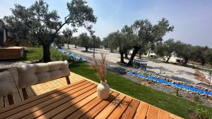 Eine weiße Vase steht auf einer Holzbank in einem Park. in der Unterkunft ELIES TINY GLAMPING in Ayvalık