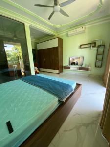 a bedroom with a large bed with a ceiling fan at Tiny home 小角落 in Tam Ðảo