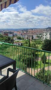 a balcony with a table and a view of a city at Precioso piso en Ourense centro in Ourense