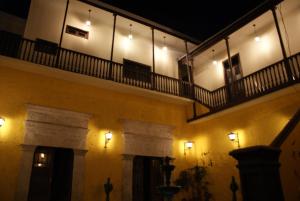 a building with a balcony with lights on it at Flying Dog Hostel Arequipa in Arequipa