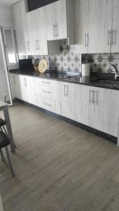 cocina con armarios blancos y suelo de madera en Precioso piso en Ourense centro en Ourense