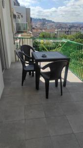 a black table and chairs on a balcony at Precioso piso en Ourense centro in Ourense