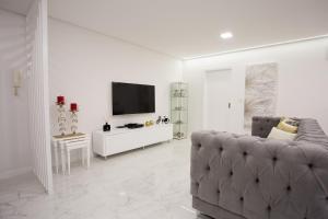 a living room with a couch and a flat screen tv at Pérola dos Anjos by LovelyStay in Funchal