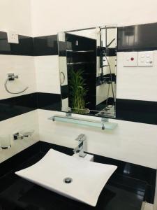 a bathroom with a white sink and a mirror at Andora Nuwara Eliya in Nuwara Eliya