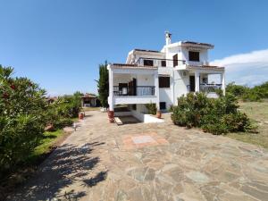 叟索波利的住宿－Gaia Olives Villa，石车道上带阳台的白色房屋