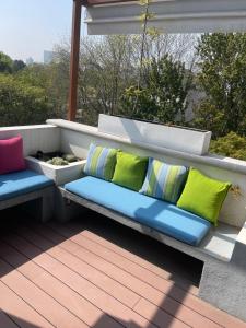 un banco con almohadas coloridas en el balcón en Residence L´ Heritage Aristóteles 225 by BlueBay, en Ciudad de México